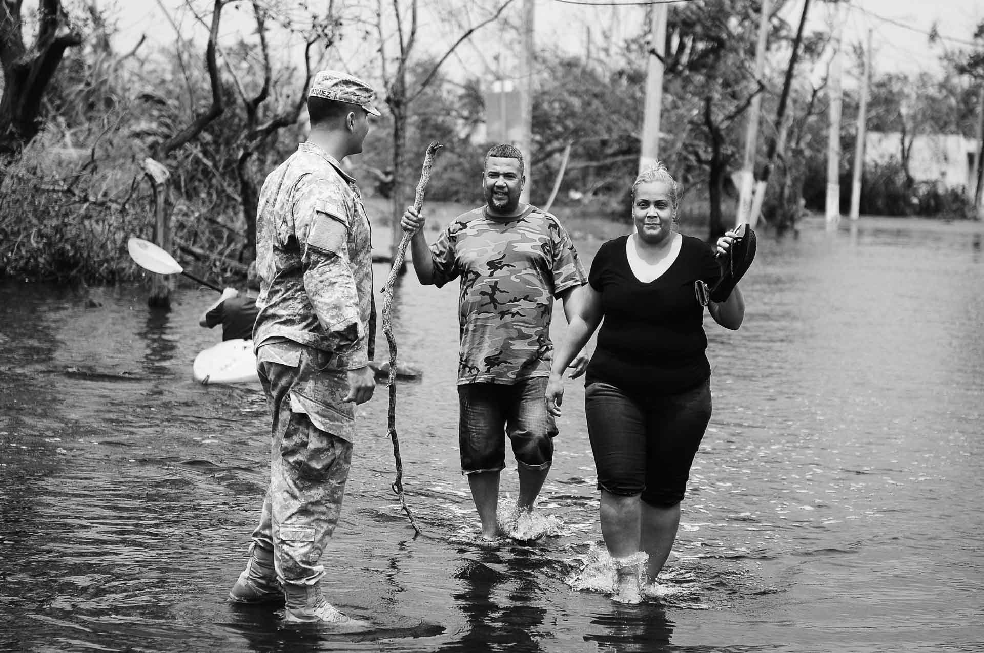 Puerto Rico National Guard Soldier helps a couple getting away from the flooded areas in Condado, San Juan, Puerto Rico after the path of Hurricane Maria. Photo by Sgt. Jose Ahiram Diaz-Ramos/PRNG-PAO