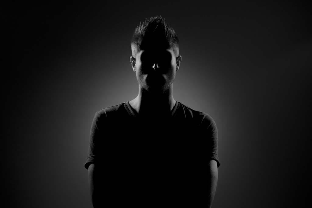 arthur-chauvineau-il5shCKsWdo-unsplash Man under the shadow in a black background with a white aura